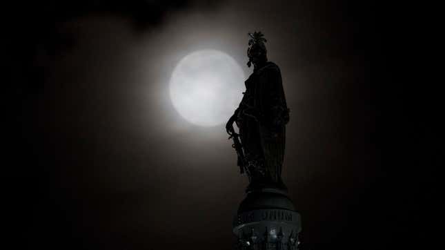 The moon behind the Statue of Freedom in Washington, DC.