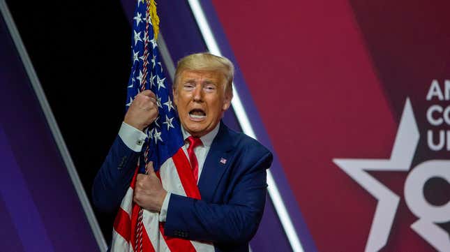 Donald Trump wrapping himself over the flag at CPAC on Feb. 29, 2020.