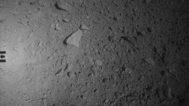 A view of Ryugu’s surface, with the shadow of Hayabusa 2 seen at far left.