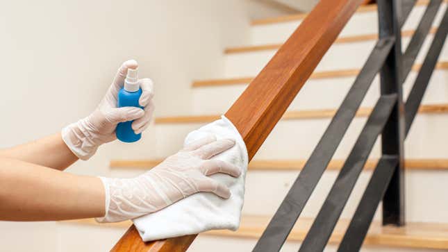 hands disinfecting a banister