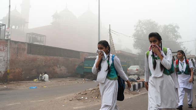 Kids in Delhi cover their faces as they walk to school amid heavy smog