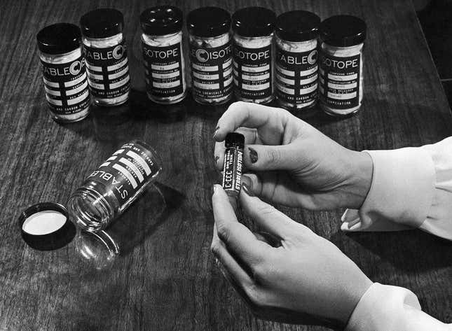 Una empleada de la planta de proceso electromagnético de Oak Ridge, donde se concentran los isótopos estables, sostiene un vial que contiene el isótopo estable Molibdeno 92, el 22 de enero de 1948. Los isótopos estables se pueden manipular sin riesgo para la persona. A diferencia de los isótopos radiactivos, no emiten radiación y, por lo tanto, pueden manipularse de forma segura.