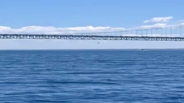 A small plane flies underneath the Mackinac Bridge On July 28, 2020