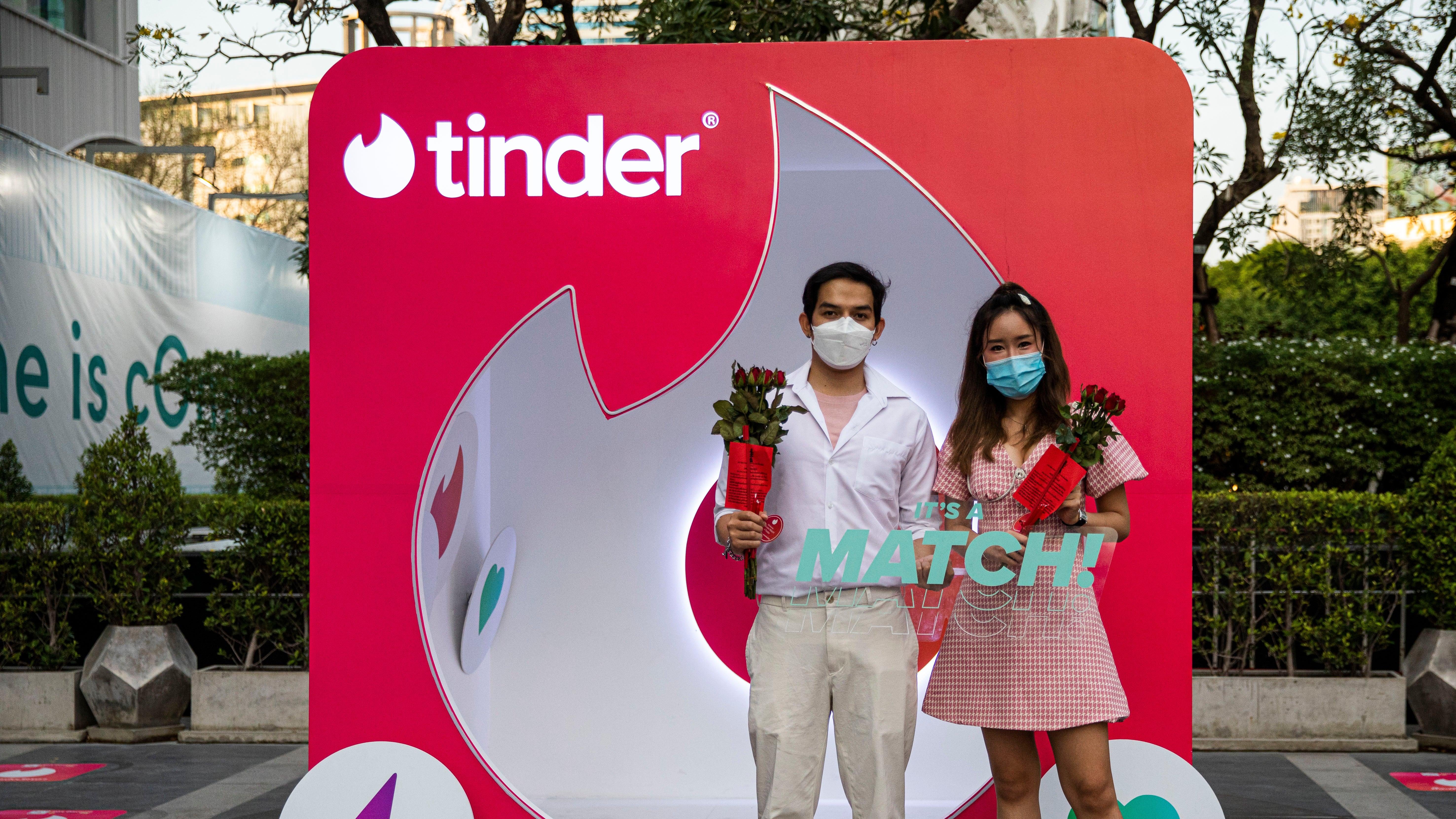 زوجان تايلانديان يقفان في كشك Tinder في يوم عيد الحب في 14 فبراير 2022 في بانكوك ، تايلاند.  الشعب التايلاندي يشارك في مراسم الصلاة برعاية Tinder في ضريح تريمورتي ، الملقب بـ "مرقد الحب"في يوم عيد الحب. 