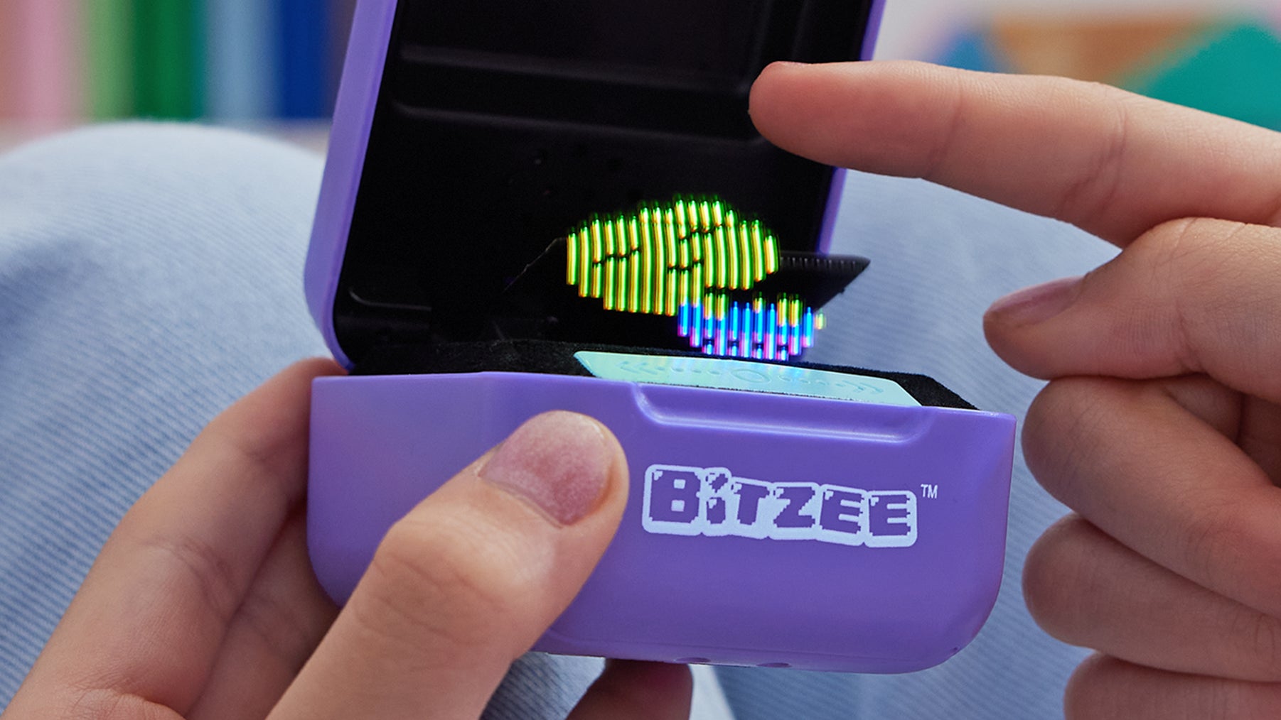 مستخدم يلمس حيوانه الأليف الرقمي Bitzee بإصبع السبابة.