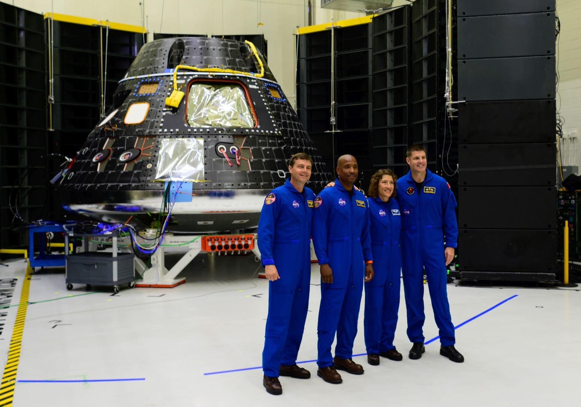 طاقم أرتميس 2 يقف مع مركبة أوريون الفضائية في مركز كينيدي للفضاء التابع لناسا في فلوريدا.