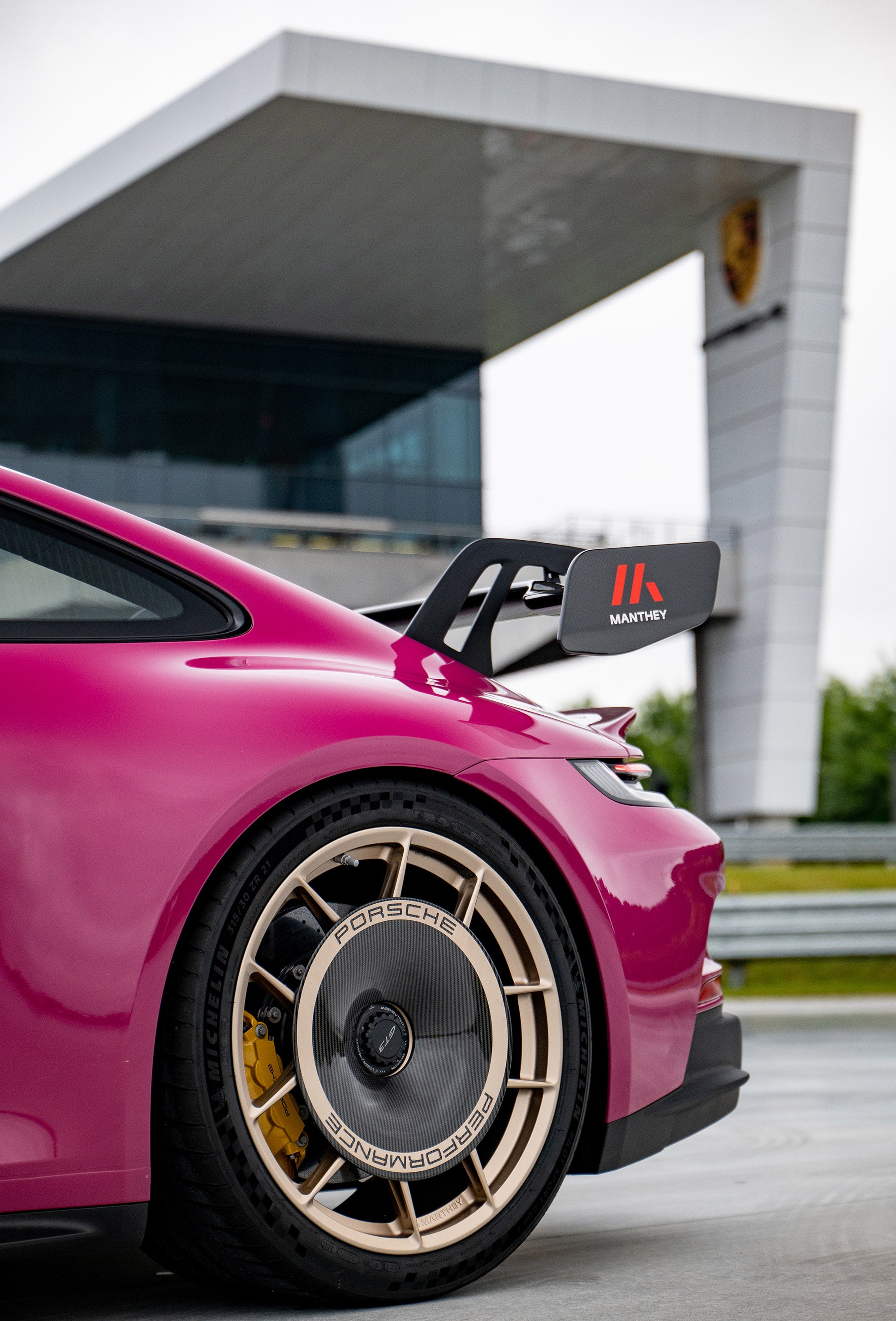 Κοντινό πλάνο της πίσω αεροτομής και του τροχού του ζαφείριου Porsche 911 GT3 εξοπλισμένο με το Manthey Performance Kit.
