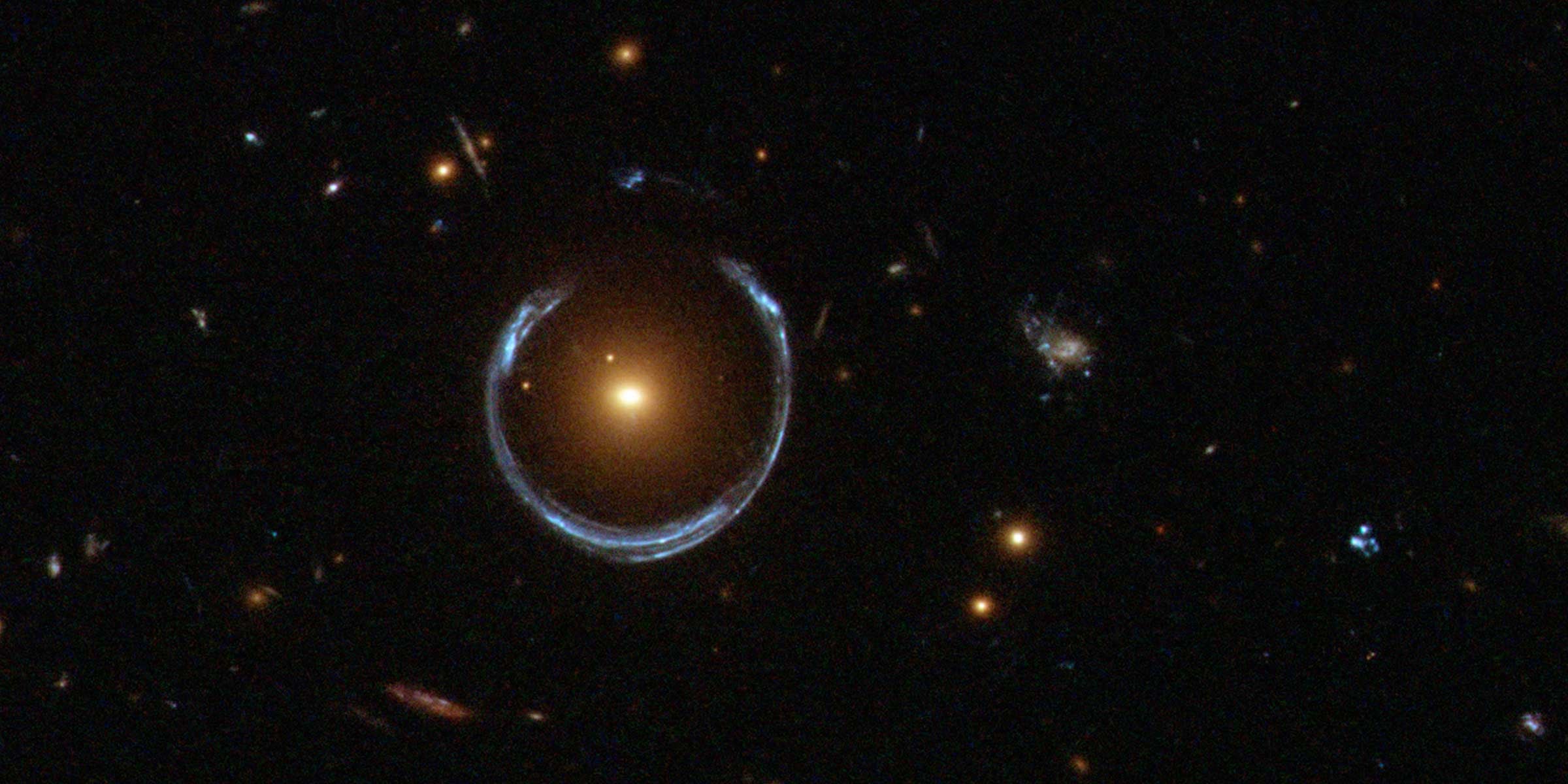 تحيط حلقة أينشتاين بمجرة حمراء مضيئة ، وهو مثال صارخ على عدسة الجاذبية.