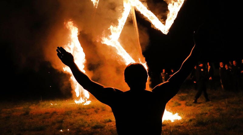 Members of the National Socialist Movement, one of the largest neo-Nazi groups in the US, hold a swastika burning after a rally on April 21, 2018 in Draketown, Georgia.