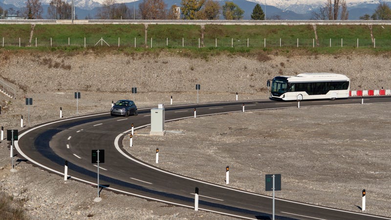 Photo of an electric car and electric bus on a wireless charging road
