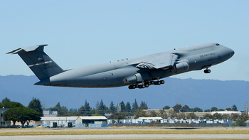 The C-5 containing 32 tons of satellite and equipment takes off at Moffett Field.