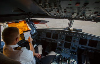 An Iberia Airlines pilot touches the screen of an iPad during a demonstration inside a cockpit of a passenger plane at Terminal 4 of Madrid&#039;s Adolfo Suarez Barajas airport