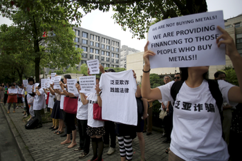 Protesters holding signs gather outside Shanghai&#039;s banking regulator to protest against Fanya in September 2015.