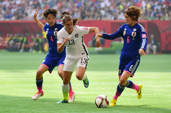 Jul 5, 2015; Vancouver, British Columbia, CAN; United States forward Alex Morgan (13) drives the ball between Japan defender Saki Kumagai (4) and midfielder Mizuho Sakaguchi (6) in the first half of the final of the FIFA 2015 Women&#039;s World Cup at BC Place Stadium.