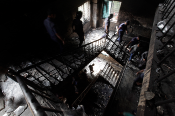 Members of the police inspect a garment factory after a devastating fire in Savar November 25, 2012. A fire swept through Tazreen Fashion factory in the Ashulia industrial belt of Dhaka, on the outskirts of Bangladesh&#039;s capital killing more than 100 people, the fire brigade said on Sunday, in the country&#039;s worst ever factory blaze.