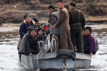 People are transported on a boat from the North Korean side of the Yalu River to an island north of the town of Sinuiju, North Korea, April 1, 2017.