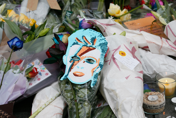 Flowers and tributes lie at a mural of David Bowie in Brixton, south London, January 11, 2016. David Bowie, a music legend who used daringly androgynous displays of sexuality and glittering costumes to frame legendary rock hits &quot;Ziggy Stardust&quot; and &quot;Space Oddity&quot;, has died of cancer.