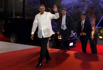 U.S. President Barack Obama, wearing the traditional Philippine &quot;barong&quot; shirt, waves as he arrives for a welcome dinner during the Asia-Pacific Economic Cooperation (APEC) summit in the capital city of Manila, Philippines November 18, 2015.