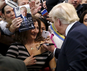Republican presidential candidate Donald Trump (R) autographs the chest of a woman at his campaign rally in Manassas, Virginia December 2, 2015. Republican presidential front-runner Trump said on Wednesday his plan for combating Islamic State militants involves targeting not just the group&#039;s fighters but also their families.