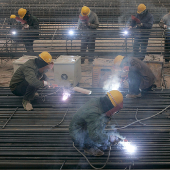 Labourers weld steel bars at a construction site in Taiyuan, Shanxi province, China.