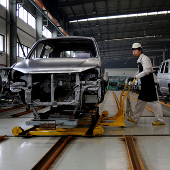An employee pushes a car along a Zotye Automobile Co., Ltd assembly line in Jinhua, Zhejiang province, April 3, 2013. China imposing long-debated stringent fuel economy standards makes life tougher for cash-strapped small domestic brands that are already struggling amid a slowdown of the world&#039;s biggest auto market. Picture taken April 3, 2013.