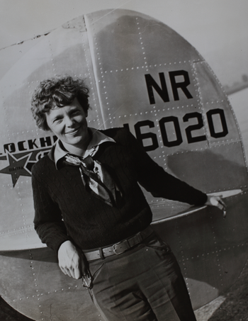 Amelia Earhart in front of a plane.