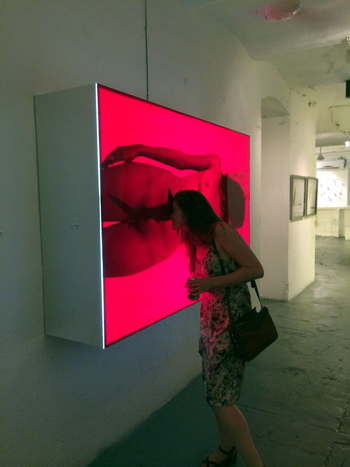 A visiting American peers into an artwork at la Fabrica de Arte Cubano.