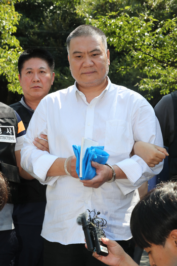 Chinese murder suspect Chen Guorui speaks to reporters after re-enacting his crime in Jeju, South Korea.