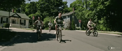 A gif showing kids bicycling down the street.