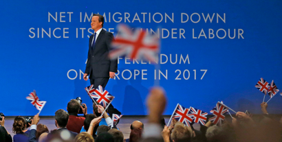 Delegates wave flags as Britain's Prime Minister David Cameron takes to the stage to deliver his keynote address to the Conservative Party Conference in Birmingham, central England October 1, 2014. REUTERS/Darren Staples (BRITAIN - Tags: POLITICS) - RTR48H4K