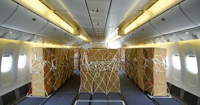 The inside of a Boeing 777-300 jet with the seats stripped away and replaced by strapped-down boxes of cargo.