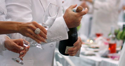 A man corks a champagne bottle as he participates in the White Dinner in Quebec City August 18, 2011. Guests are required to be dressed in white and bring their own food, drink and cutlery. According to the organisers, the event, which was held for the first time in Quebec City, attracted close to 700 people. REUTERS/Mathieu Belanger (CANADA - Tags: SOCIETY) - GM1E78J0TN701