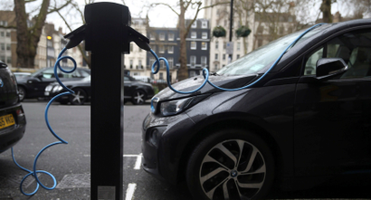 Electric cars are plugged into a charging point in London