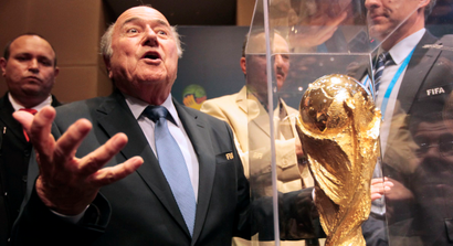 FIFA President Sepp Blatter gestures next to the World Cup trophy after a media conference in Sao Paulo June 5, 2014. The 2014 World Cup will be held in 12 cities in Brazil from June 12 to July 13. REUTERS/Paulo Whitaker (BRAZIL - Tags: SPORT SOCCER WORLD CUP TPX IMAGES OF THE DAY) - RTR3SFAT