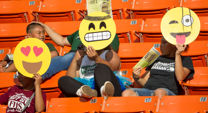 People with emoji masks at a football game.