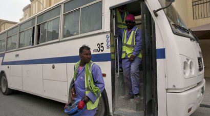 In this photo taken during a government organized media tour, foreign workers arrive at their housing facility after their shift building the Al-Wakra Stadium for World Cup in Doha, Qatar, Monday, May 4, 2015