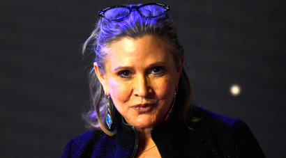 Carrie Fisher poses for cameras as she arrives at the European Premiere of Star Wars, The Force Awakens