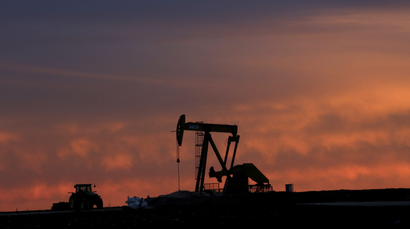 In this photo made Monday, Dec. 22, 2014, a well pump works at sunset on a farm near Sweetwater, Texas.