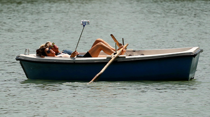 Two woman take a selfie on a boat during the unusual high temperatures at Retiro park in Madrid, Spain