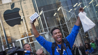 One of the first customers to purchase the Apple iPhone 5S celebrates after exiting the Apple Retail Store on Fifth Avenue in Manhattan, New York September 20, 2013