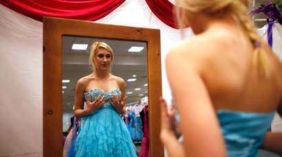 Jasmine Boyle, 17, tries on a prom dress at the Glamour Gowns event in Los Angeles, California March 28, 2014. The event gives prom dresses to more than 350 young women in the Los Angeles foster care system every year. Picture taken March 28, 2014. REUTERS/Lucy Nicholson (UNITED STATES - Tags: SOCIETY) - RTR3J4O3