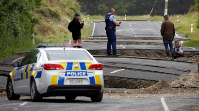 Policemen and locals look at damage following an earthquake, along State Highway One near the town of Ward, south of Blenheim on New Zealand's South Island, November 14, 2016.