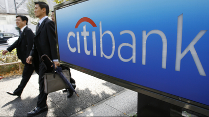 Men walk past a Citibank sign outside its Tokyo branch.
