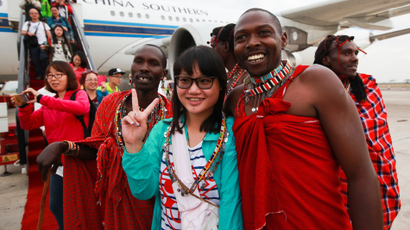 A Chinese tourist poses with traditional Kenyan Masaai dancers upon her arrival with a China Southern Airline plane at Jomo Kenyatta International Airport in Nairobi.