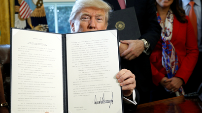 After signing, U.S. President Donald Trump holds up an executive order rolling back regulations from the 2010 Dodd-Frank law on Wall Street reform at the White House in Washington February 3, 2017.