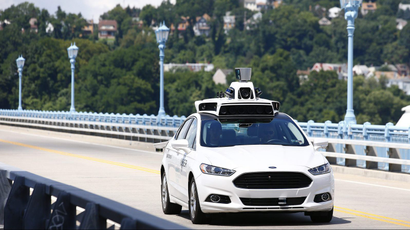 FILE - In this Thursday, Aug. 18, 2016, file photo, Uber employees test a self-driving Ford Fusion hybrid car, in Pittsburgh. After taking millions of factory jobs, robots could be coming for a new class of worker: people who drive for a living.