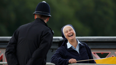 A nun smiles as she chats with a police officer as she waits to see Pope Benedict XVI's pope mobile cross Lambeth Bridge in central London, September 17, 2010. Pope Benedict's security was in the spotlight on Friday after London police arrested five men on suspicion of preparing an attack in Britain. It was not clear if the planned attack was related to the pope's visit or when it was to have taken place, but it prompted police to take another look at security for the pontiff, who was on the second day of his visit to Britain. REUTERS/Andrew Winning (BRITAIN - Tags: RELIGION POLITICS) - RTR2IGPX