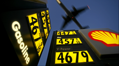Gasoline prices are advertised at a gas station near Lindbergh Field as a plane approaches to land in San Diego, California June 1, 2008.