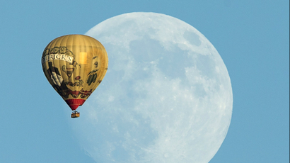 A hot air ballon floats past a rising moon over Rancho Santa Fe, California.