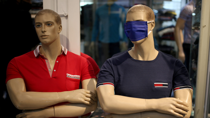 Two mannequins in a store, one wearing a cloth mask over its eyes.